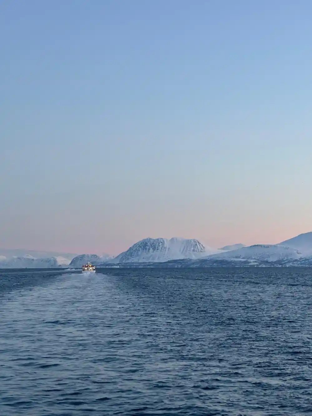 Distant snowy mountains across quiet arctic waters