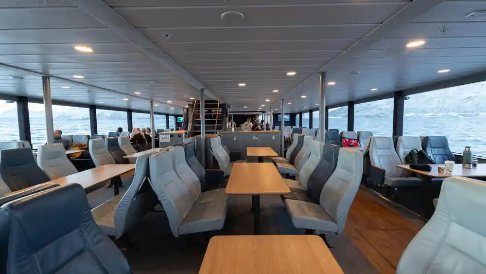 Interior of passenger ferry with seating and ocean view