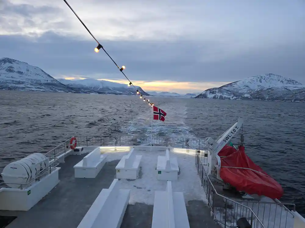 Ship deck with zipline over snowy mountains and fjord