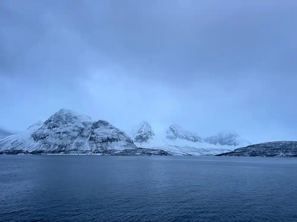 Snowy mountain landscape across calm Arctic waters
